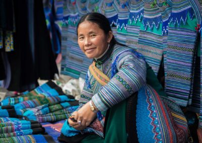 A Blue Hmong Woman Sells Fabrics In The Bac Ha Market Outside Sa