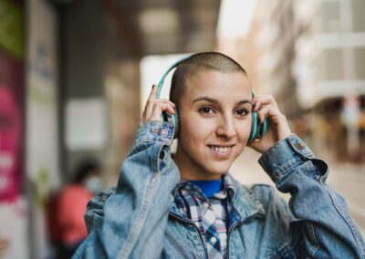 Young Bald Girl Listening Music Playlist While Waiting At Bus Station In The City