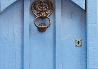 Blue Door With Black Door Knocker In Wrought Iron.