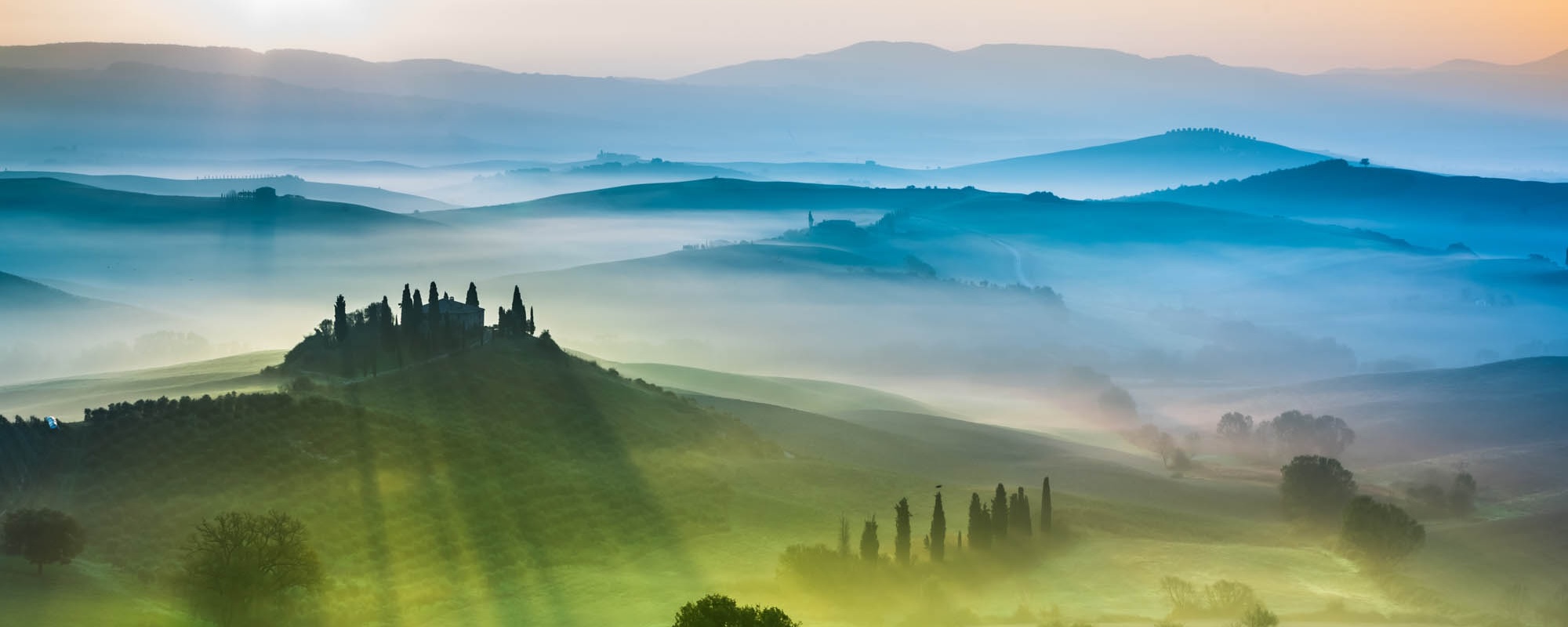 Beautiful View Of Green Fields And Meadows At Sunset In Tuscany