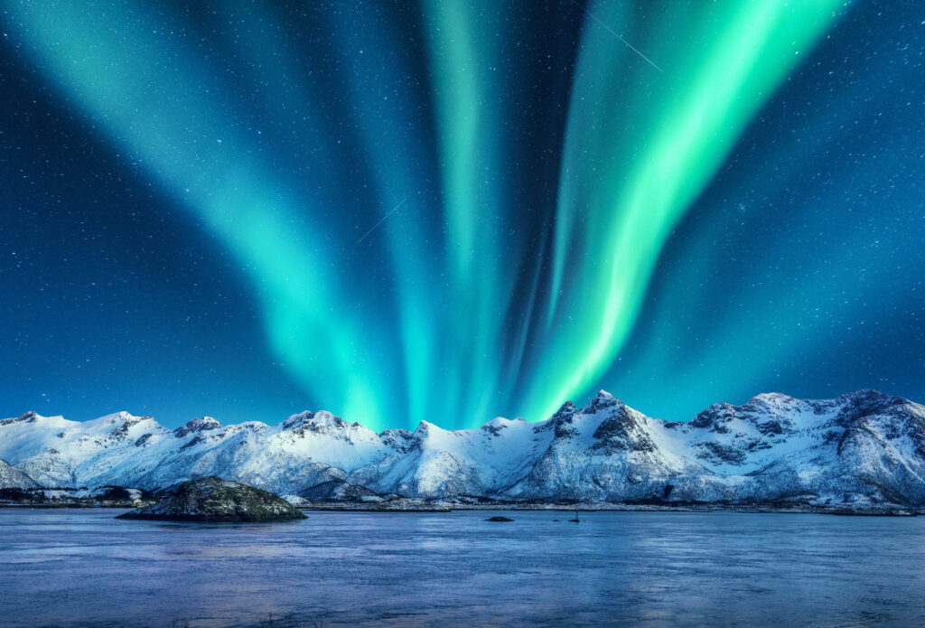 Aurora Borealis Above The Snow Covered Mountains In Lofoten Aurora Borealis Above The Snow Covered Mountains In Lofoten