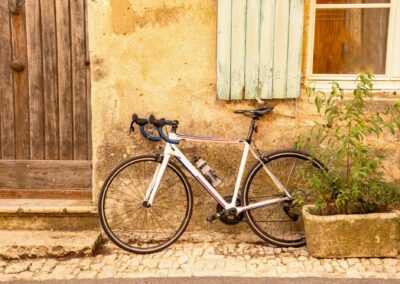 A Bicycle (road Bike) Leans Against An Old, Weathered House Faca