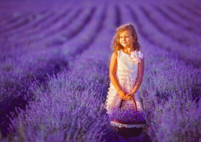 Smiling Girl Sniffing Flowers In A Lavender Field