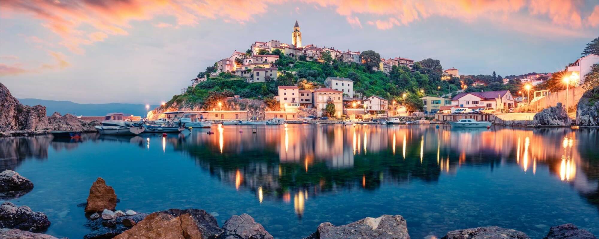 Breathtaking Evening Cityscape Of Vrbnik Town. Dramatic Summer Seascape Of Adriatic Sea, Krk Island, Croatia, Europe. Beautiful World Of Mediterranean Countries. Traveling Concept Background.
