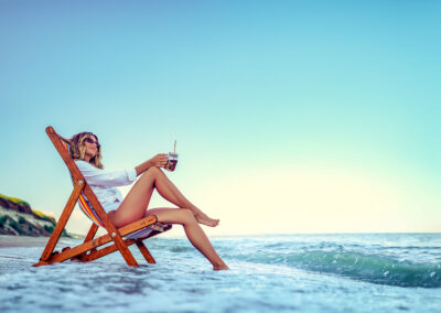 Pretty Woman Relaxing On A Lounger Beach And Drinks Soda Water.